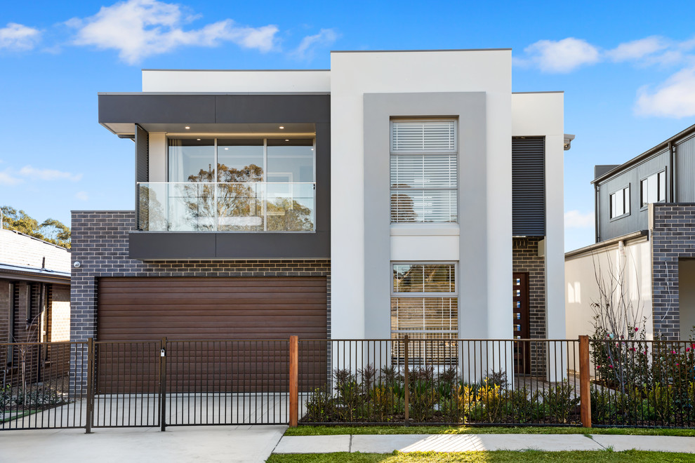 This is an example of a contemporary two-storey multi-coloured house exterior in Sydney with mixed siding and a flat roof.