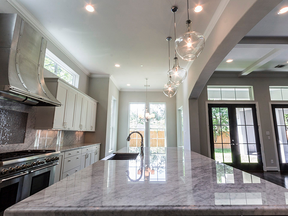 Large transitional dark wood floor open concept kitchen photo in Houston with a farmhouse sink, marble countertops, stone slab backsplash, stainless steel appliances, shaker cabinets, white cabinets and an island