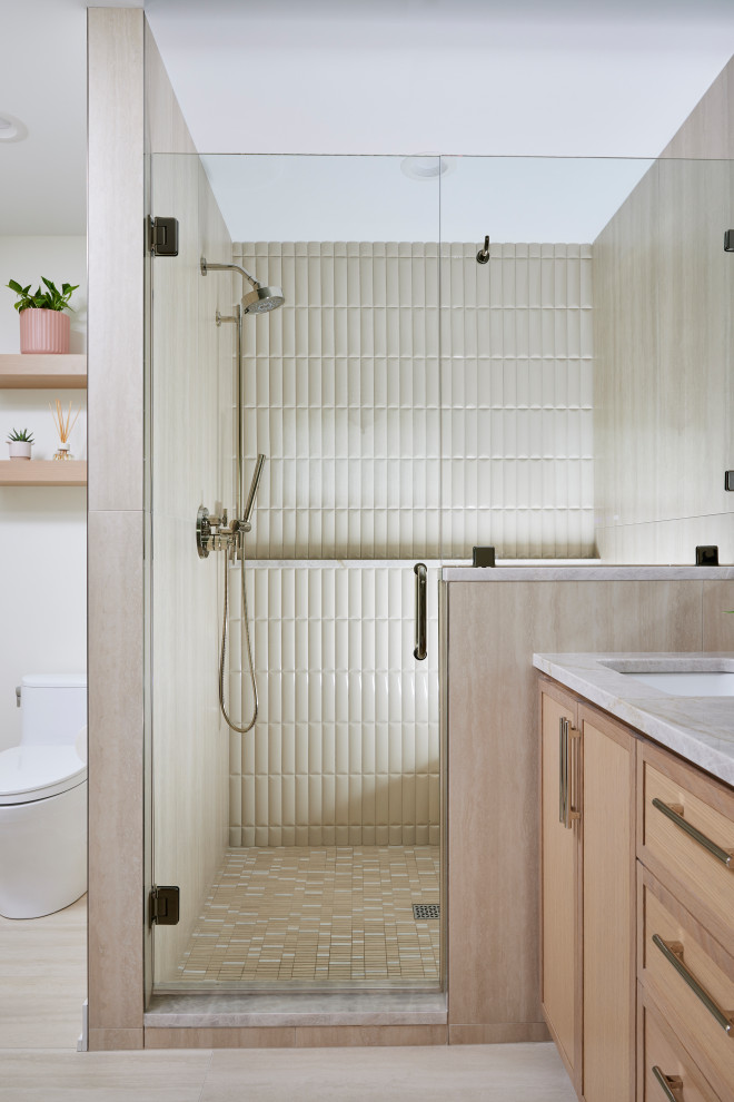 Inspiration for a large contemporary master beige tile and ceramic tile ceramic tile, beige floor and double-sink freestanding bathtub remodel in Minneapolis with shaker cabinets, light wood cabinets, a one-piece toilet, beige walls, an undermount sink, quartzite countertops, a hinged shower door, beige countertops, a niche and a built-in vanity