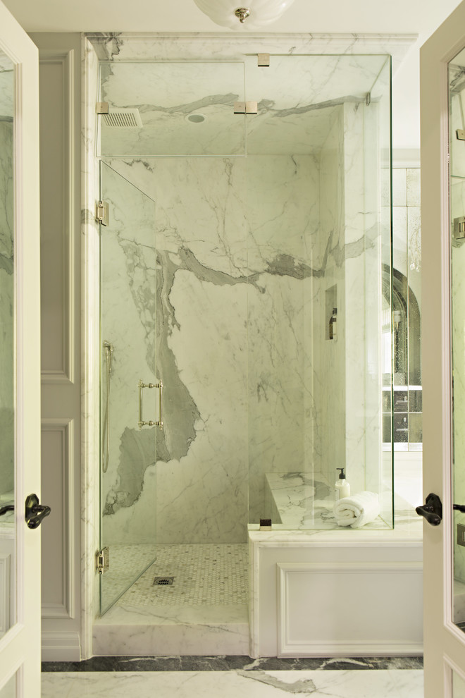 This is an example of a traditional master bathroom in Los Angeles with a corner shower, stone slab and a hinged shower door.