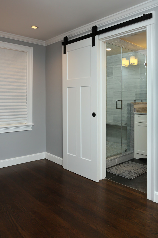 Inspiration for a mid-sized transitional 3/4 bathroom in Boston with shaker cabinets, white cabinets, dark hardwood floors, brown floor, an alcove shower, gray tile, pebble tile, grey walls, an undermount sink, marble benchtops and a hinged shower door.