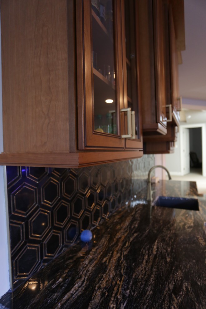 Inspiration for a medium sized traditional single-wall wet bar in Baltimore with a submerged sink, raised-panel cabinets, medium wood cabinets, granite worktops, black splashback, marble splashback, plywood flooring, beige floors and black worktops.