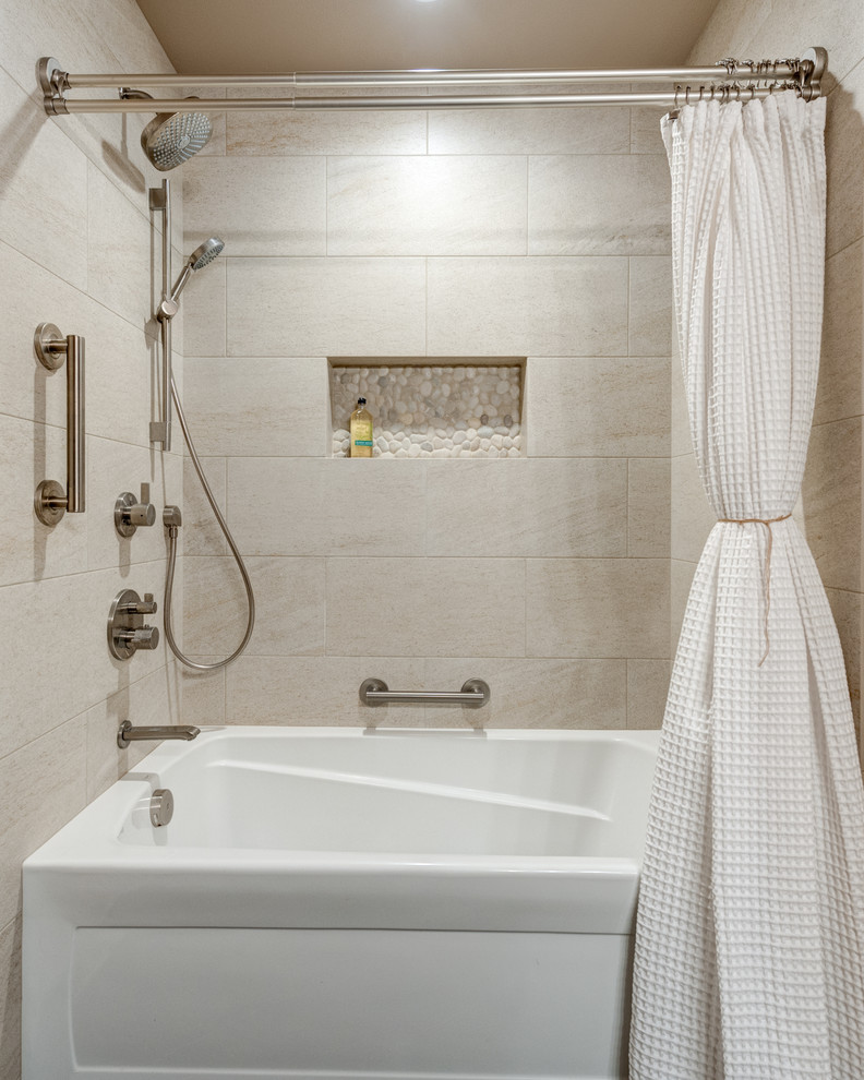 This is an example of a mid-sized traditional bathroom in Portland with raised-panel cabinets, medium wood cabinets, a drop-in tub, a shower/bathtub combo, a two-piece toilet, multi-coloured tile, porcelain tile, beige walls, porcelain floors, an undermount sink, engineered quartz benchtops, brown floor and a shower curtain.