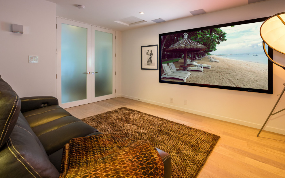 Foto di un piccolo home theatre minimalista con pareti bianche, pavimento in legno massello medio, TV a parete e pavimento beige