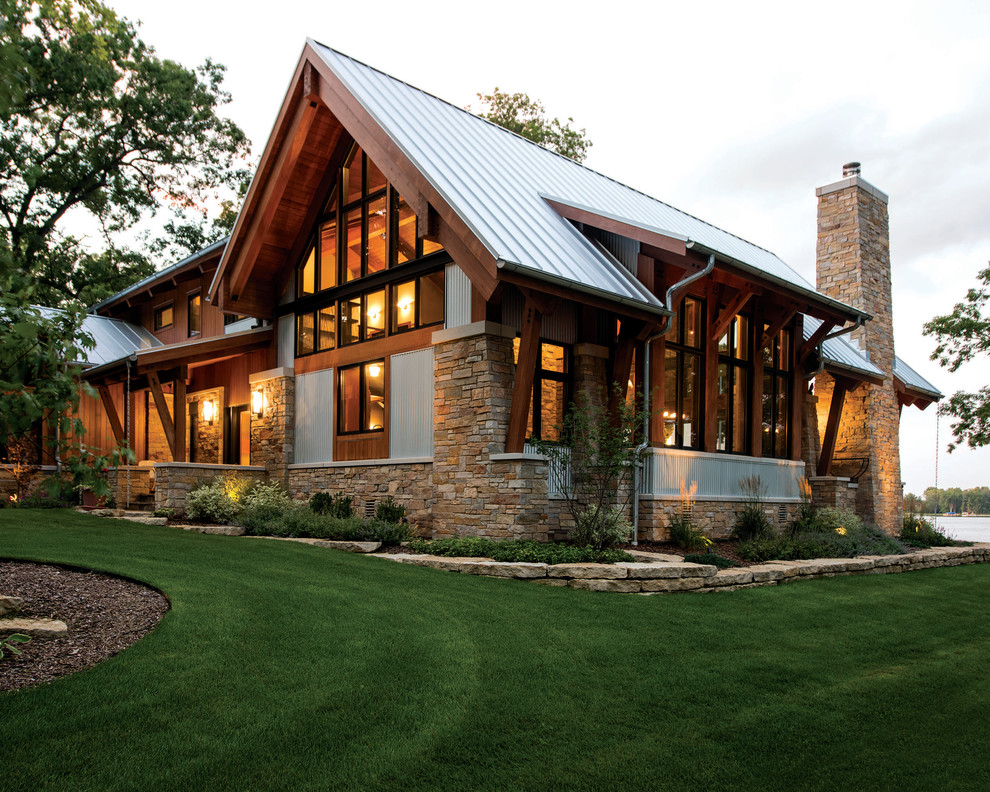 Inspiration for a large country two-storey exterior in Other with mixed siding and a flat roof.