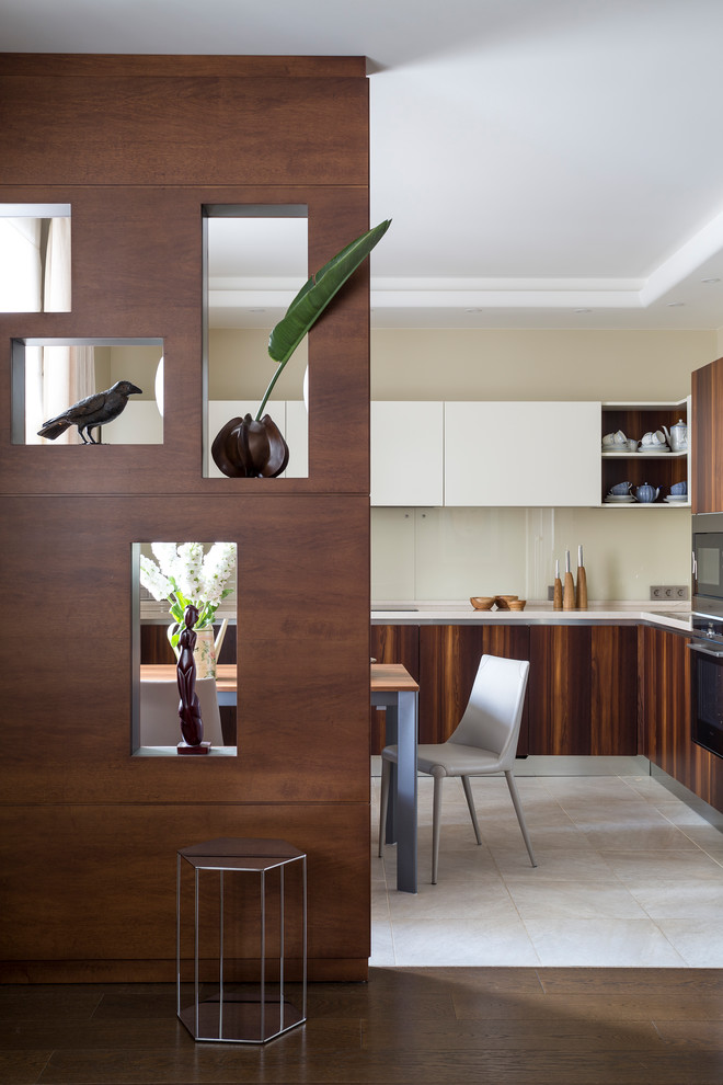 Design ideas for a contemporary l-shaped open plan kitchen in Moscow with flat-panel cabinets, dark wood cabinets, beige splashback, glass sheet splashback and no island.