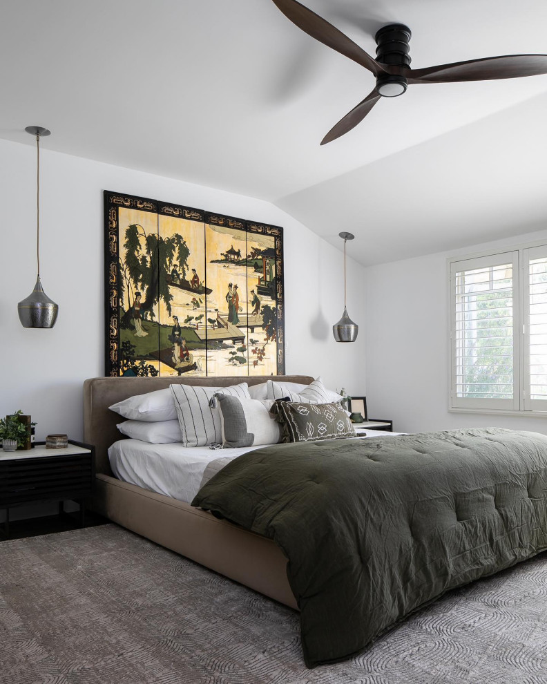 Large contemporary master bedroom in Santa Barbara with white walls, dark hardwood flooring, a standard fireplace, a stone fireplace surround, black floors and panelled walls.