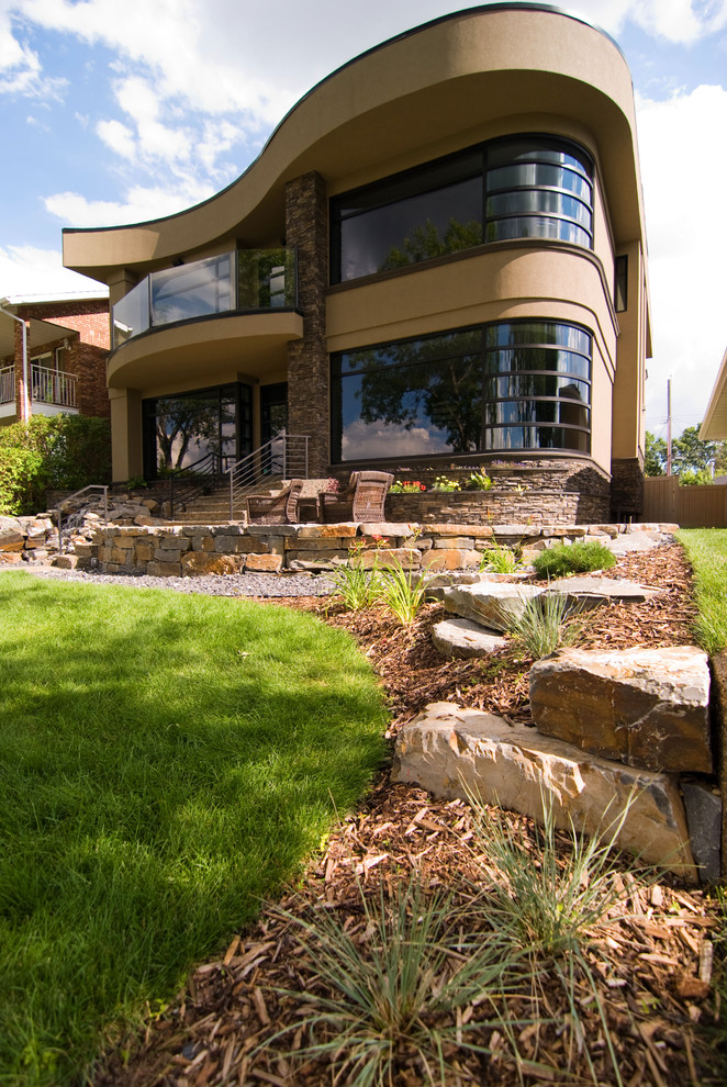 Inspiration for a large contemporary partial sun front yard stone retaining wall landscape in Calgary for spring.