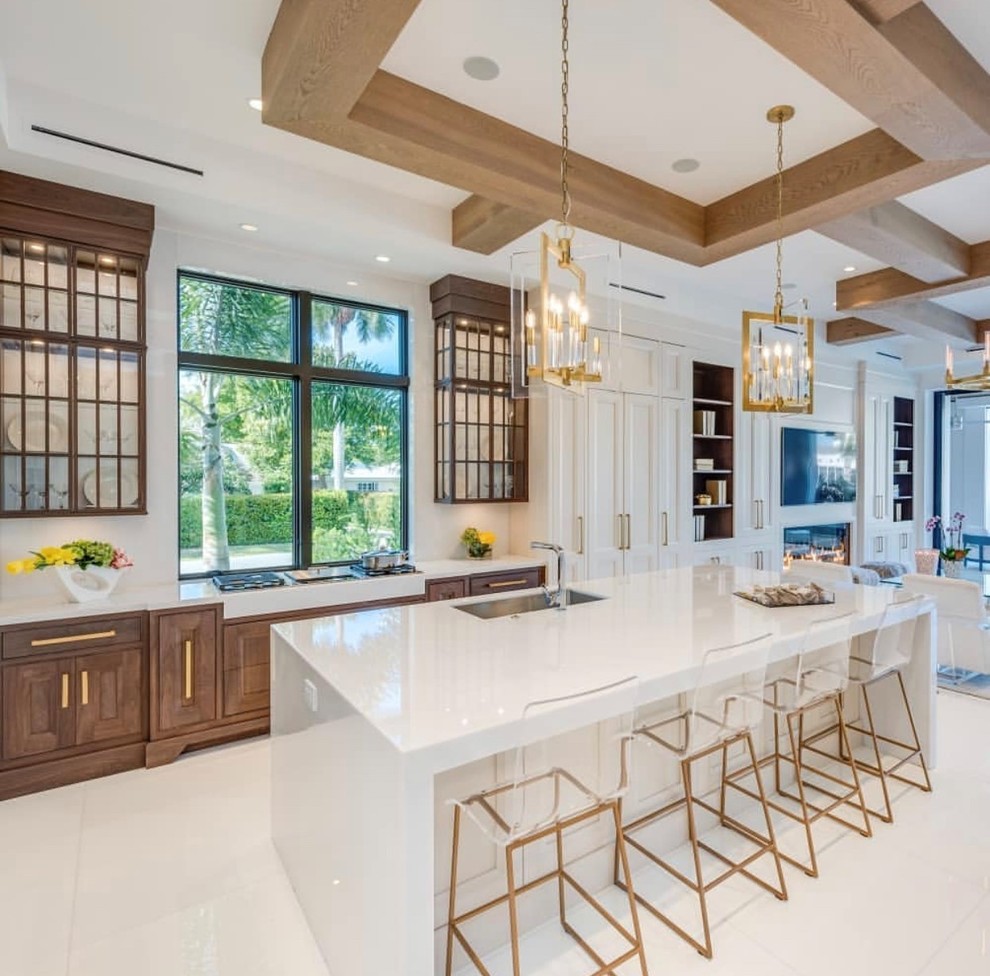This is an example of a mid-sized eclectic l-shaped eat-in kitchen with an undermount sink, recessed-panel cabinets, white cabinets, quartzite benchtops, white splashback, panelled appliances, terrazzo floors, with island, white floor and white benchtop.