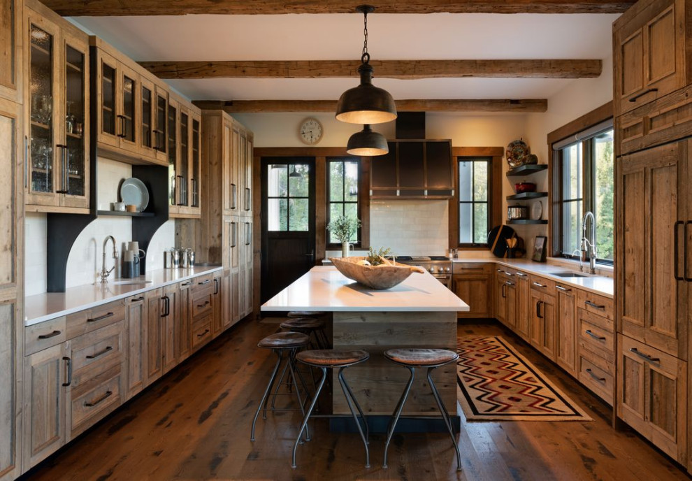 Urige Küche mit Landhausspüle, Küchengeräten aus Edelstahl und freigelegten Dachbalken in Sonstige