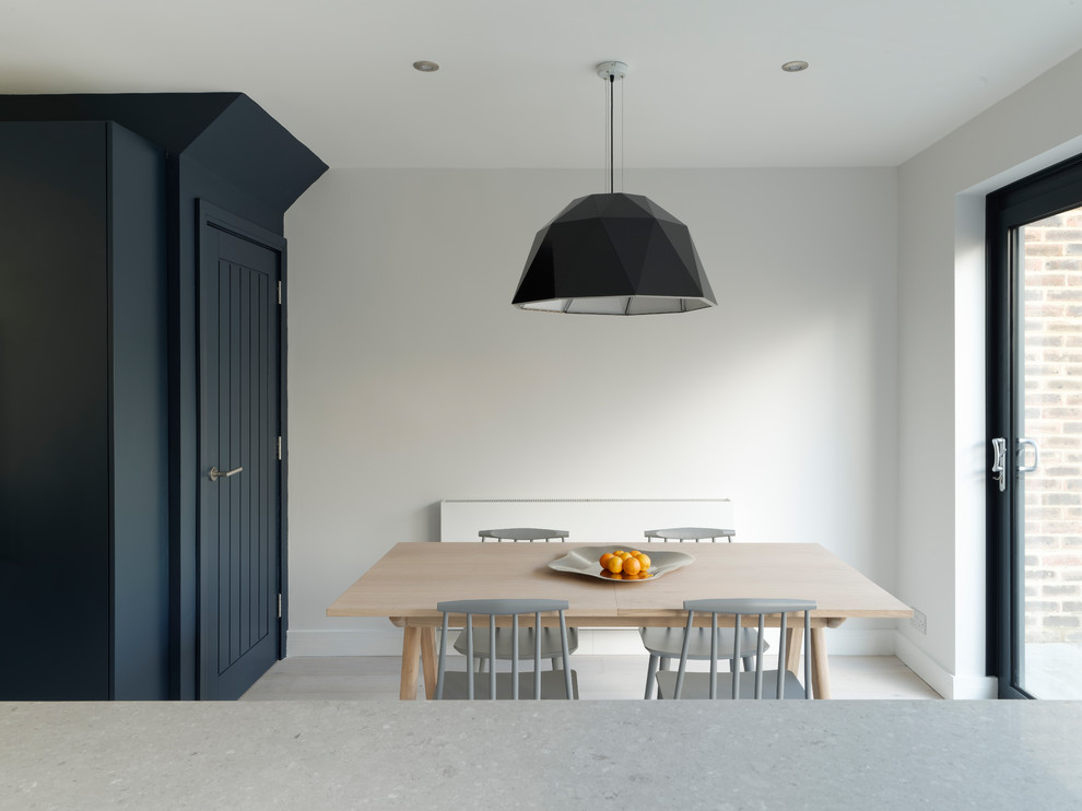 Photo of a small contemporary open plan dining in Sussex with white walls, light hardwood floors and white floor.