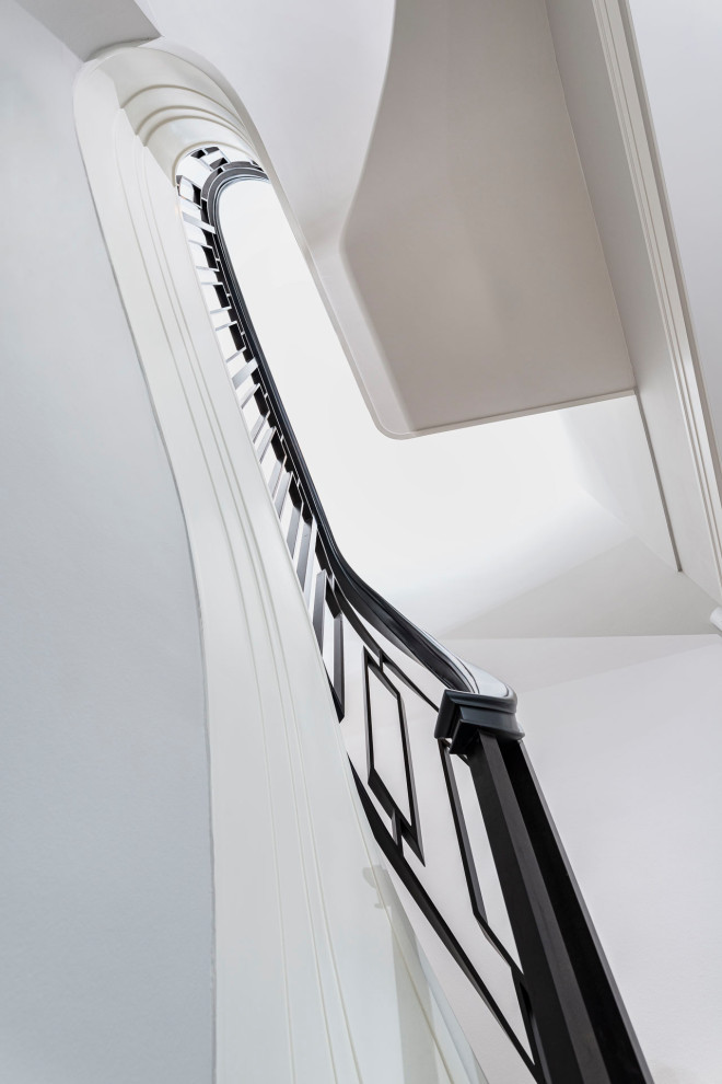 Inspiration pour un escalier courbe traditionnel avec des marches en bois, des contremarches en bois et un garde-corps en métal.