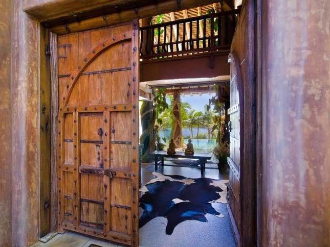 Inspiration for a large tropical front door in Sydney with a double front door, a medium wood front door and concrete floors.