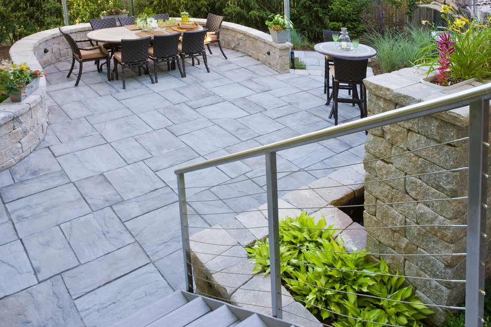 Contemporary backyard patio in Chicago with natural stone pavers.