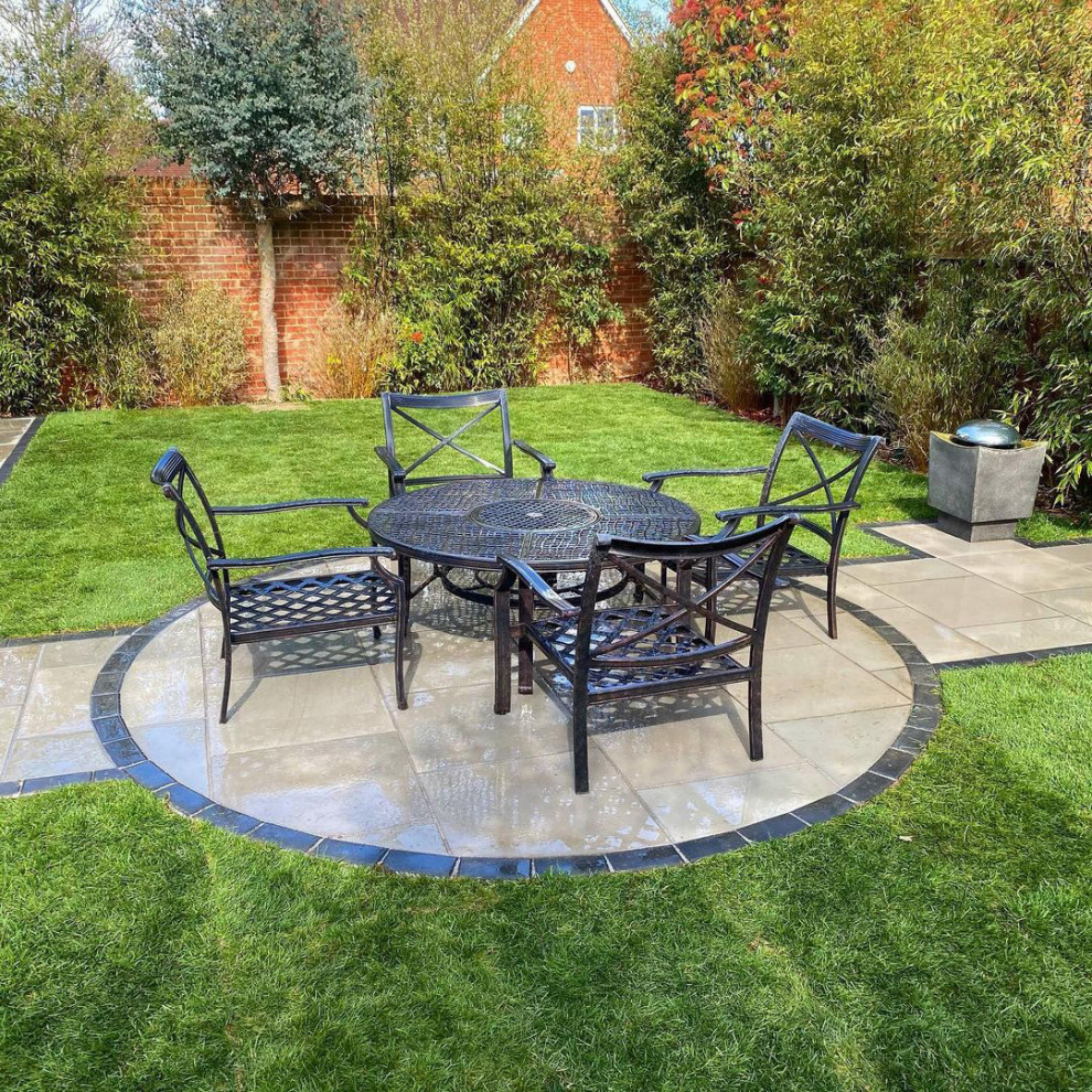 Photo of a medium sized contemporary back patio in Essex with natural stone paving.