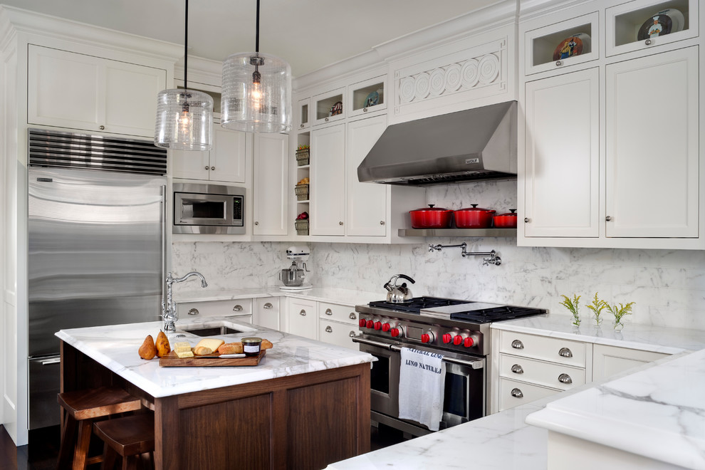 Inspiration for a traditional u-shaped kitchen in Boston with an undermount sink, recessed-panel cabinets, white cabinets, white splashback, stainless steel appliances, dark hardwood floors, with island, brown floor and white benchtop.