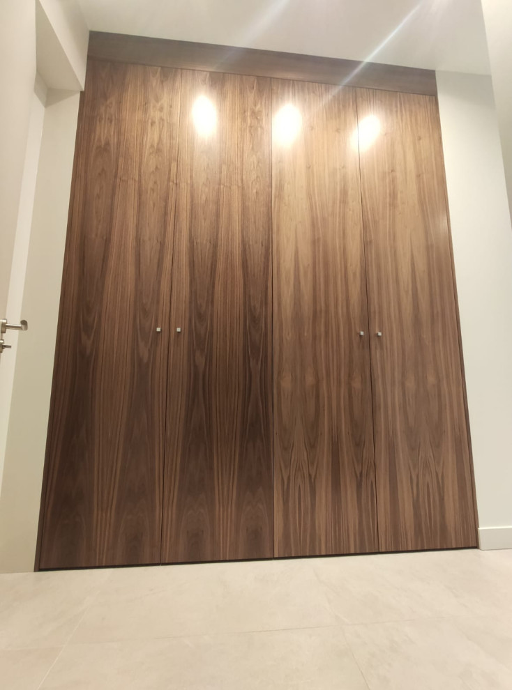Design ideas for a mid-sized transitional gender-neutral built-in wardrobe in Paris with medium wood cabinets.