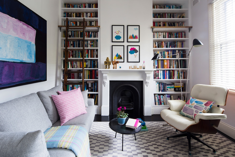 Photo of an eclectic living room in Sydney with a library, white walls and a standard fireplace.
