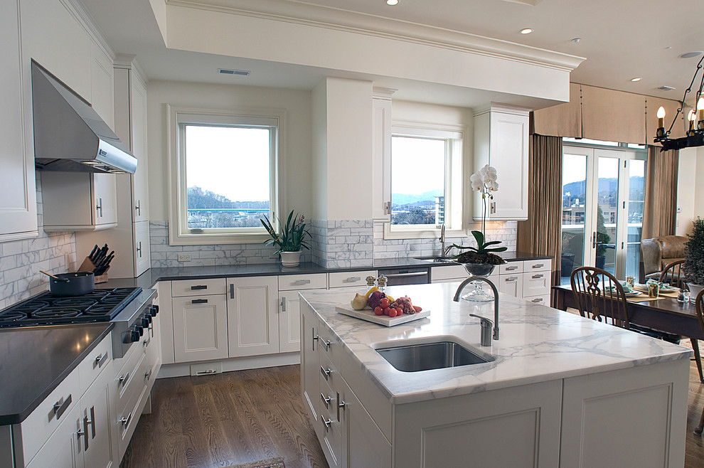 Eat-in kitchen - large transitional u-shaped medium tone wood floor eat-in kitchen idea with an undermount sink, recessed-panel cabinets, white cabinets, quartz countertops, white backsplash, subway tile backsplash, stainless steel appliances and an island