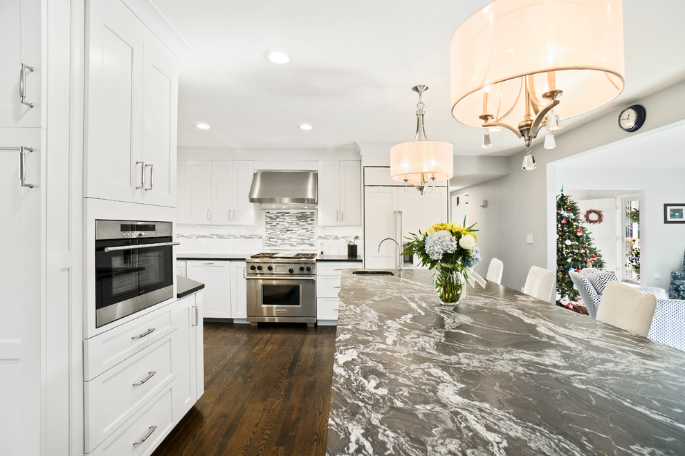 Inspiration for a huge transitional u-shaped dark wood floor and brown floor eat-in kitchen remodel in Providence with an undermount sink, recessed-panel cabinets, white cabinets, granite countertops, white backsplash, marble backsplash, stainless steel appliances and an island