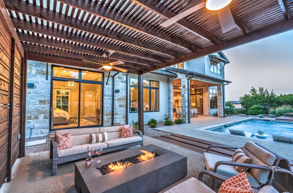 This is an example of a transitional patio in Austin with a pergola.