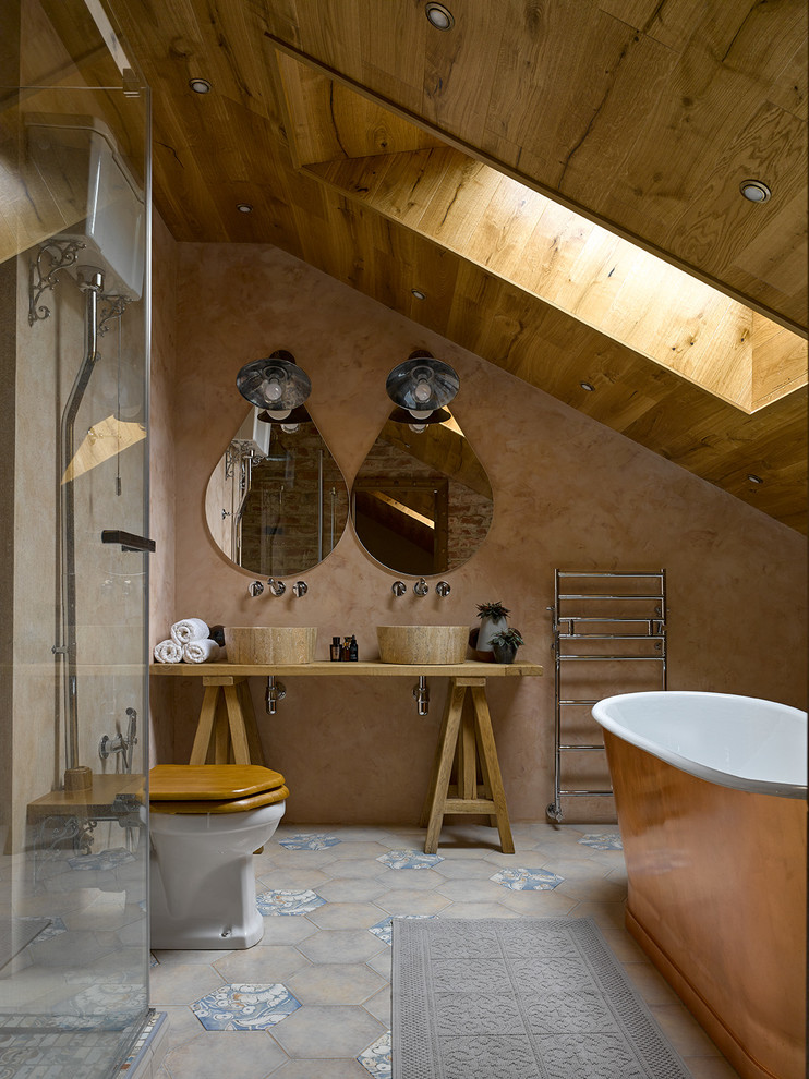 Photo of a mediterranean master bathroom in Moscow with open cabinets, a freestanding tub, a two-piece toilet, beige walls, a vessel sink, blue tile and gray tile.