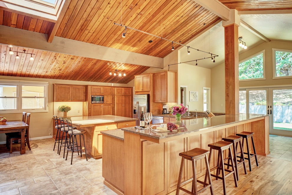 Open concept kitchen - large transitional ceramic tile open concept kitchen idea with a double-bowl sink, shaker cabinets, medium tone wood cabinets, quartz countertops, stainless steel appliances and an island
