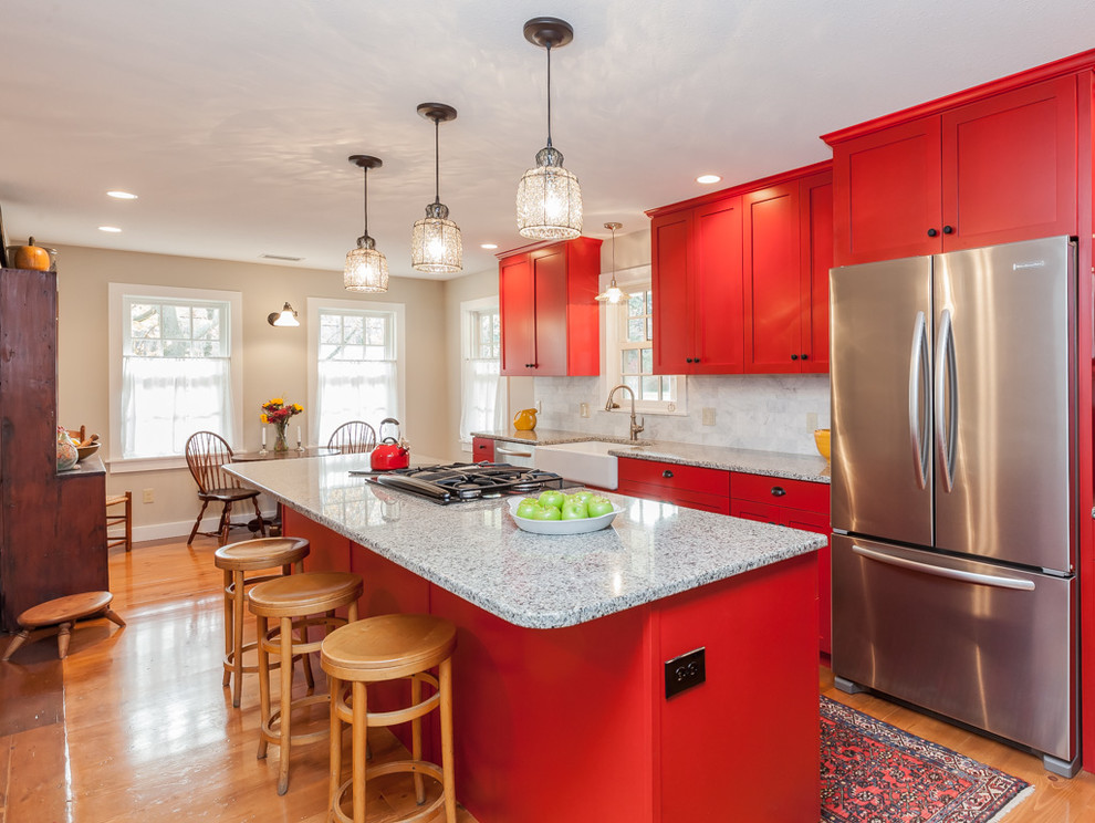 Design ideas for a mid-sized traditional galley eat-in kitchen in Boston with a farmhouse sink, shaker cabinets, red cabinets, granite benchtops, grey splashback, subway tile splashback, stainless steel appliances, light hardwood floors and with island.