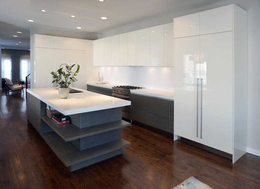 Photo of a mid-sized modern galley eat-in kitchen in Chicago with a double-bowl sink, white cabinets, white splashback, stainless steel appliances, dark hardwood floors and with island.