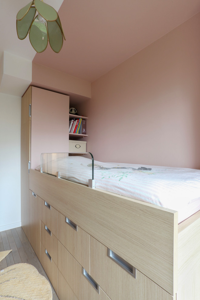 Nordisk inredning av ett litet barnrum för 4-10-åringar, med rosa väggar