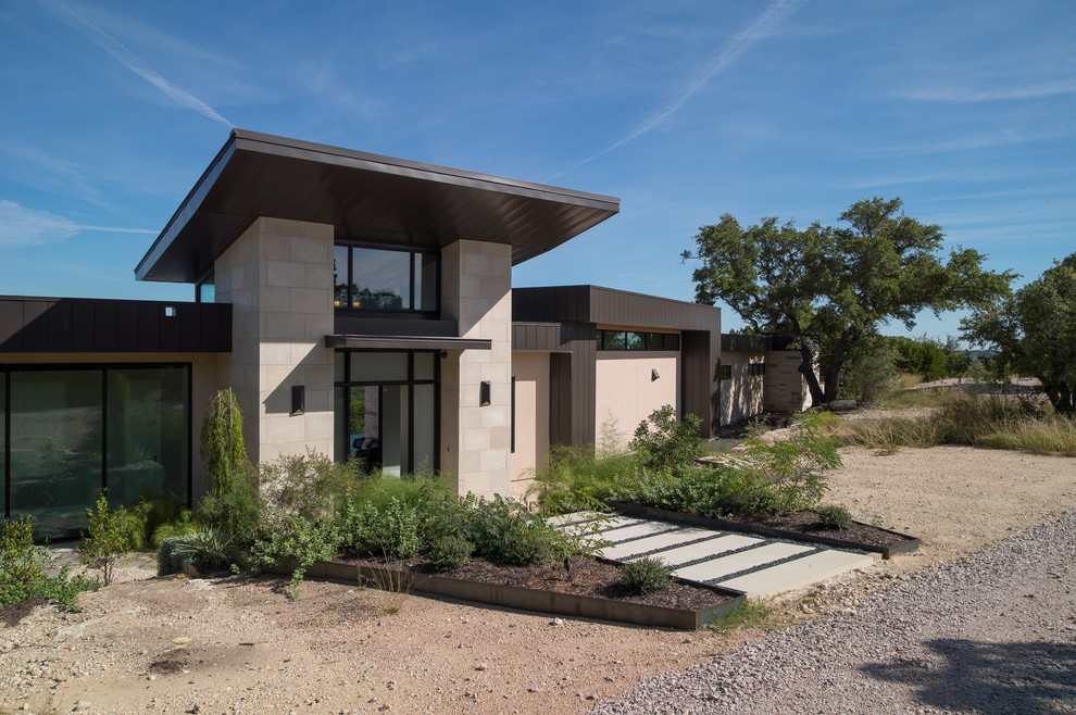 Large contemporary one-storey black house exterior in Austin with metal siding, a flat roof and a metal roof.