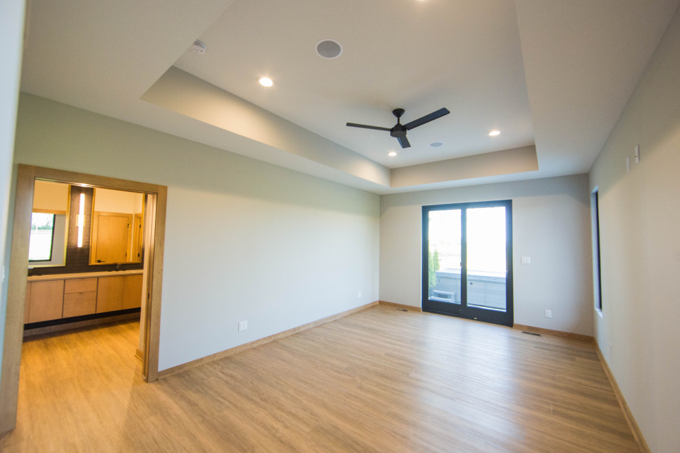 Foto de dormitorio principal minimalista grande con paredes beige, suelo de madera en tonos medios, suelo marrón y bandeja