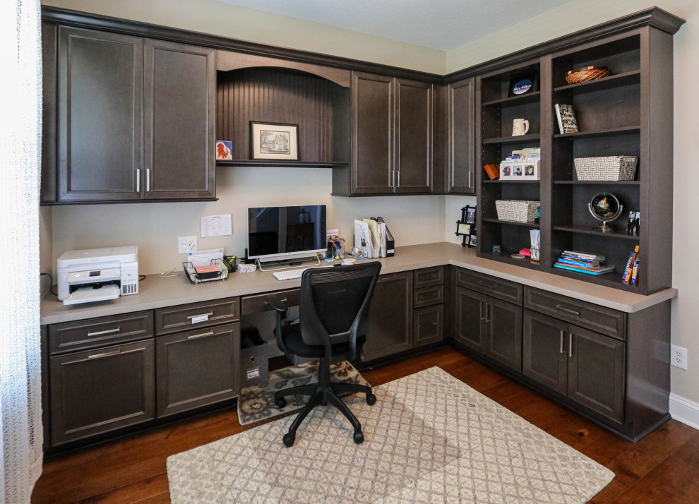 Immagine di un ufficio classico di medie dimensioni con pareti beige, pavimento in legno massello medio, pavimento marrone e scrivania incassata