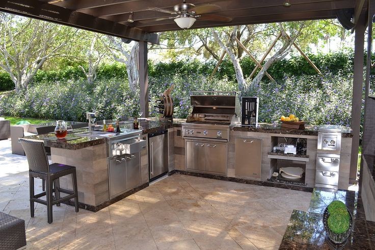 Design ideas for a mid-sized country backyard patio in Tampa with an outdoor kitchen, stamped concrete and a pergola.