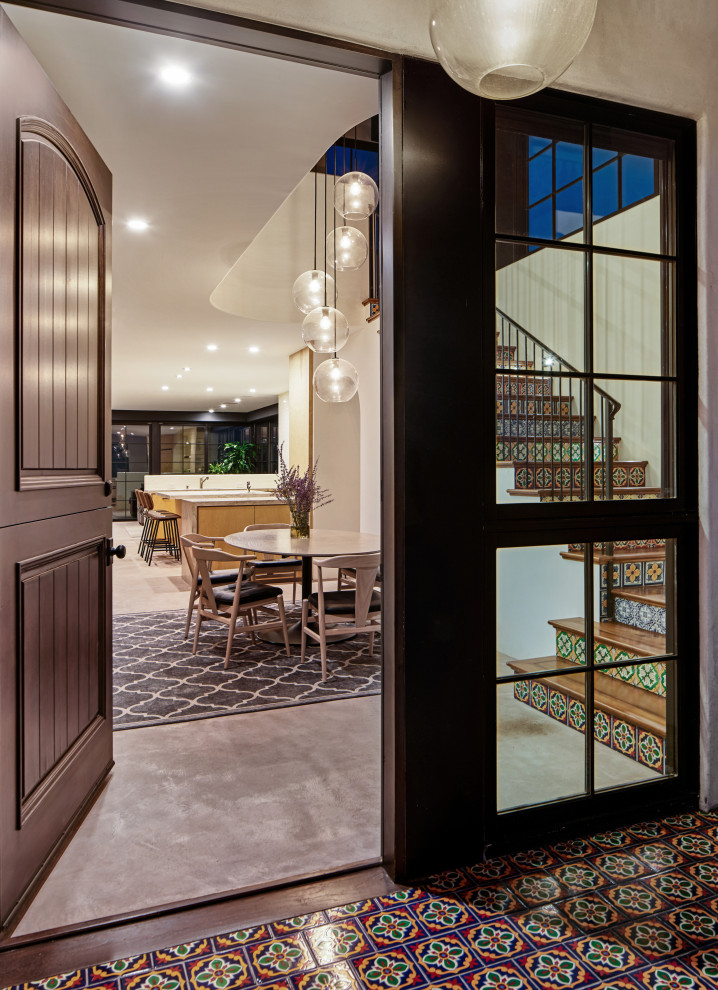 Mittelgroße Mediterrane Haustür mit weißer Wandfarbe, Betonboden, Klöntür, dunkler Holzhaustür, grauem Boden und gewölbter Decke in Los Angeles