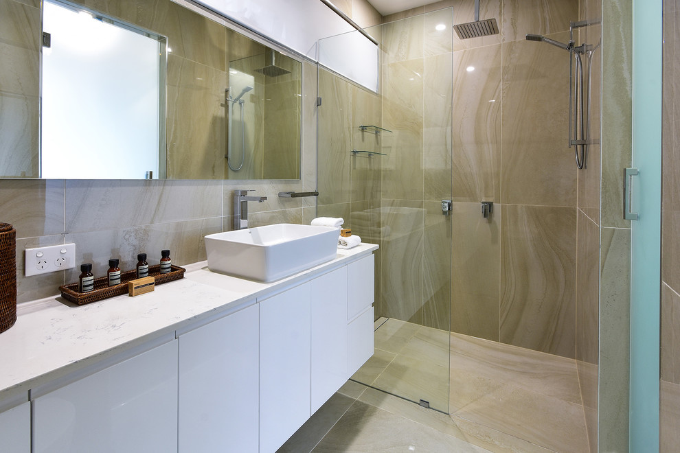 Photo of a contemporary bathroom in Other with flat-panel cabinets, white cabinets, a curbless shower, beige tile, gray tile, grey walls, a vessel sink, grey floor, a hinged shower door and white benchtops.