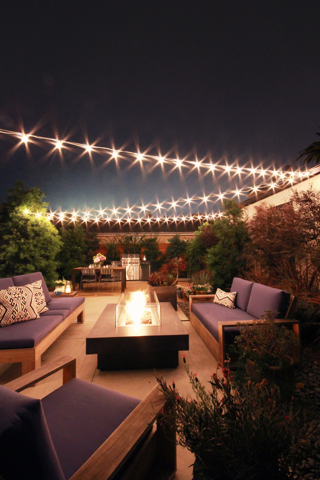 This is an example of a mid-sized modern backyard patio in Los Angeles with a fire feature and concrete pavers.