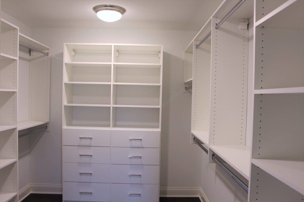 This is an example of a mid-sized traditional walk-in wardrobe in Chicago with flat-panel cabinets and white cabinets.