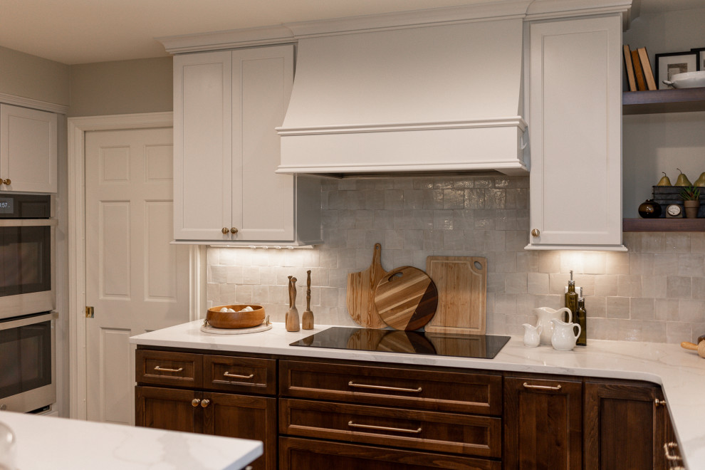 Example of a mid-sized transitional l-shaped medium tone wood floor and brown floor eat-in kitchen design with an undermount sink, medium tone wood cabinets, quartz countertops, beige backsplash, terra-cotta backsplash, stainless steel appliances, an island, white countertops and recessed-panel cabinets