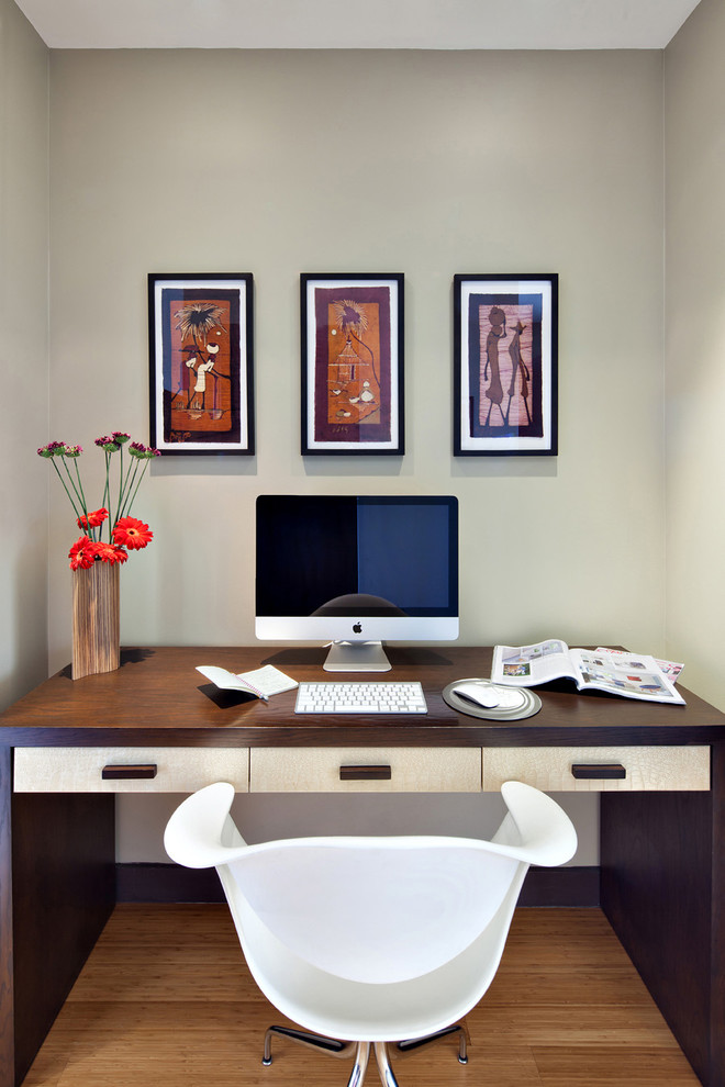 This is an example of a small modern study room in New York with medium hardwood floors and a freestanding desk.