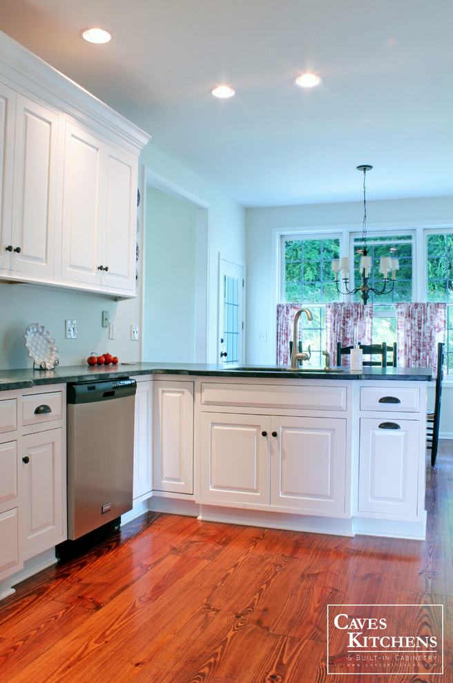 This is an example of a mid-sized transitional u-shaped eat-in kitchen in New York with an undermount sink, raised-panel cabinets, white cabinets, green splashback, stainless steel appliances, dark hardwood floors and a peninsula.