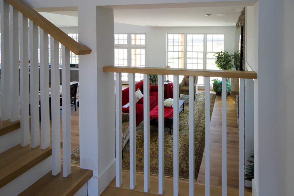 This is an example of a medium sized rural wood u-shaped wood railing staircase in DC Metro with wood risers and tongue and groove walls.