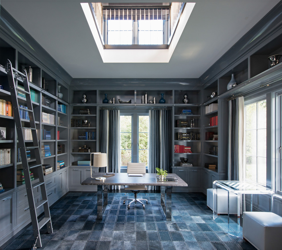 Photo of a transitional home office in New York with a library, grey walls, no fireplace, a freestanding desk, carpet and grey floor.