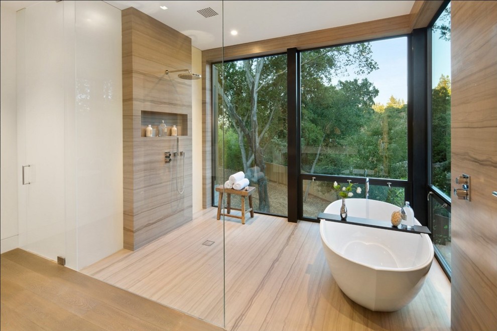 This is an example of a mid-sized modern master bathroom in San Francisco with a freestanding tub, a curbless shower, beige tile, white walls, beige floor, an open shower, limestone and limestone floors.