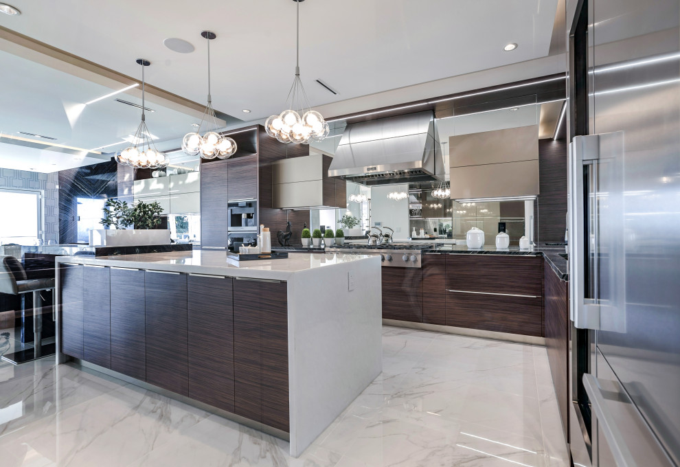 Design ideas for a modern galley eat-in kitchen in Vancouver with flat-panel cabinets, medium wood cabinets, granite benchtops, mirror splashback, stainless steel appliances, marble floors, with island, white floor and black benchtop.