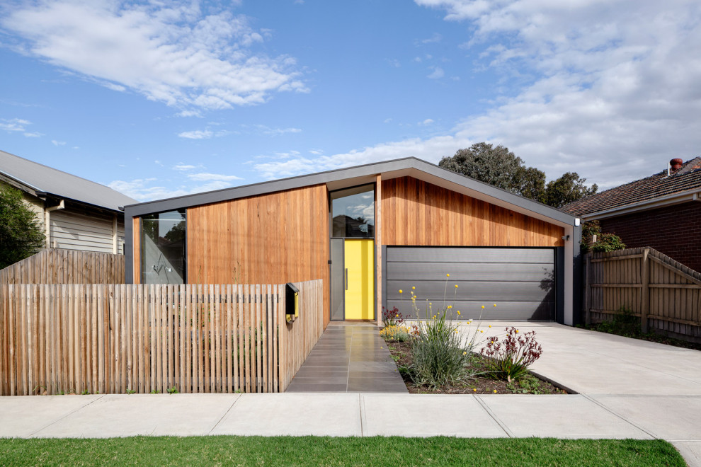 Mid-sized contemporary one-storey grey house exterior in Melbourne with metal siding, a gable roof, a metal roof and a grey roof.