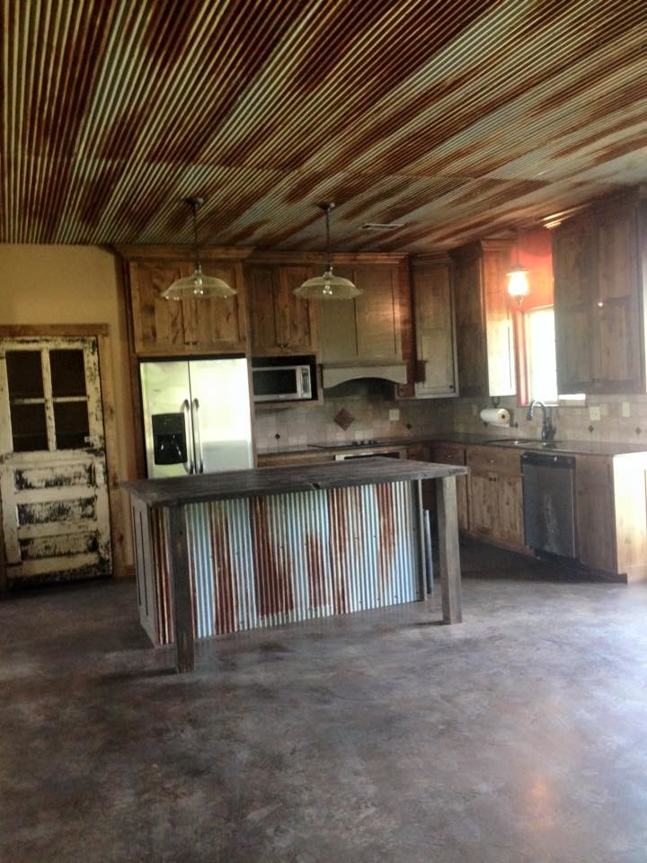 Inspiration for a rustic concrete floor kitchen remodel with an undermount sink, flat-panel cabinets, medium tone wood cabinets, granite countertops, beige backsplash, stone tile backsplash, stainless steel appliances and an island