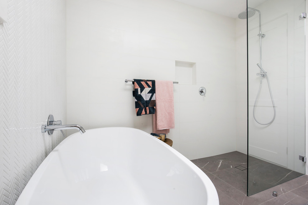 Inspiration for a large contemporary master bathroom in Sydney with shaker cabinets, white cabinets, a freestanding tub, an open shower, a wall-mount toilet, white tile, porcelain tile, white walls, porcelain floors, an integrated sink, engineered quartz benchtops, grey floor, an open shower and white benchtops.