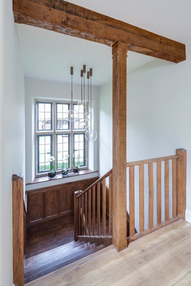 Photo of a country wood u-shaped staircase in Gloucestershire with wood risers and wood railing.