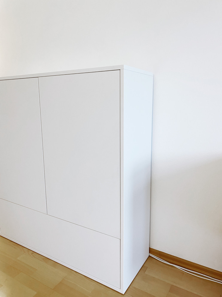 Mittelgroßes, Abgetrenntes Modernes Wohnzimmer mit weißer Wandfarbe, braunem Holzboden, verstecktem TV, braunem Boden, Tapetendecke und Wandpaneelen in München